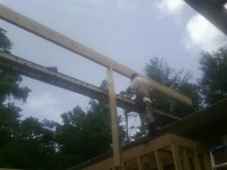 Carpenter setting a ridge beam over a new addition frame — Ice Dam Removal by Roofing Brothers in Old Orchard Beach