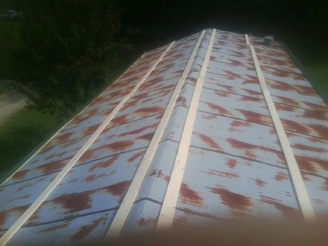 Rusted metal roof panels with new wood purlins before replacement — Storm Damage Roof Repair in Old Orchard Beach by Roofing Brothers