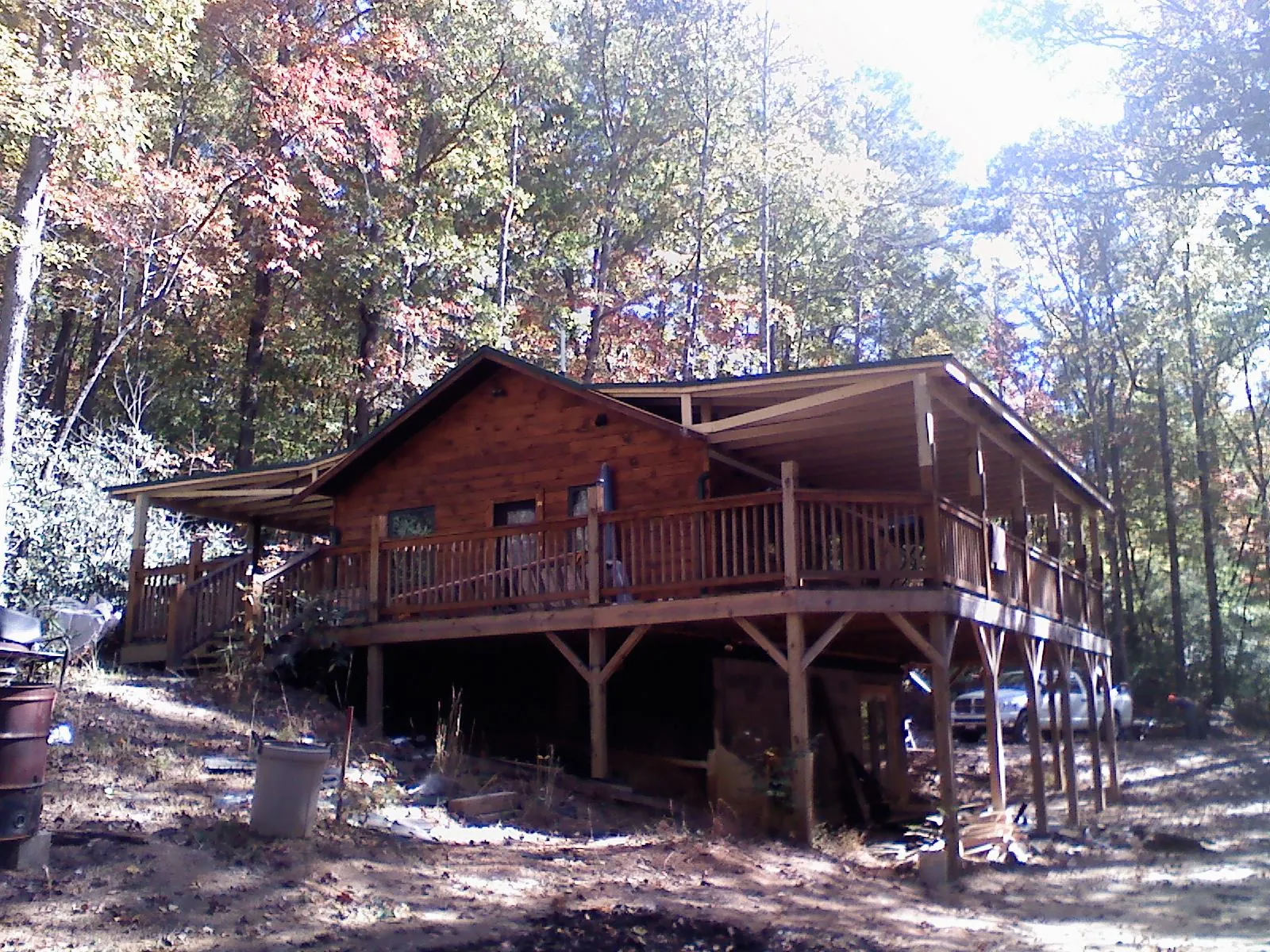 Log cabin with a wraparound porch and metal roof in the fall in Old Orchard Beach