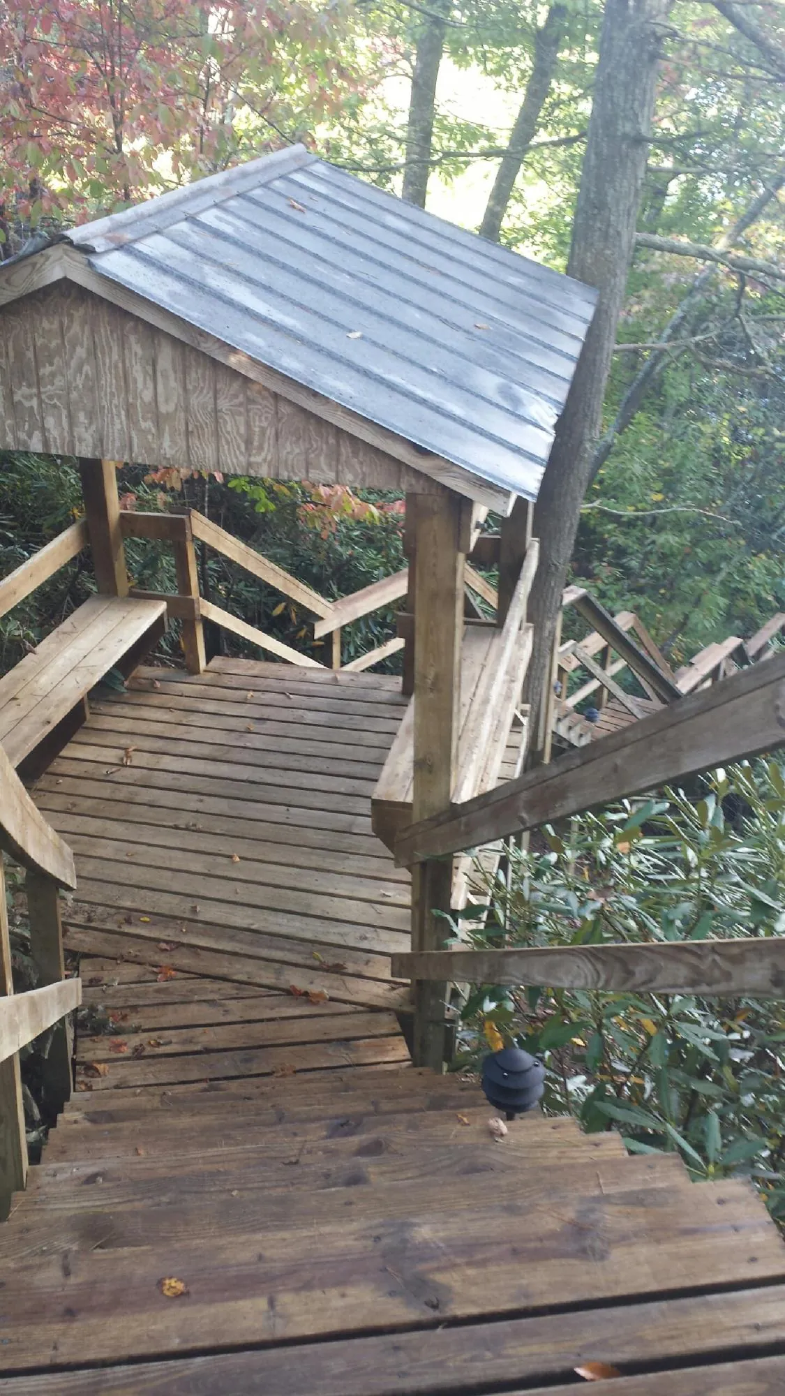 Metal roofed shelter over wooden steps on a wooded walkway — Skylight Repair & Installation work by our crew in Old Orchard Beach