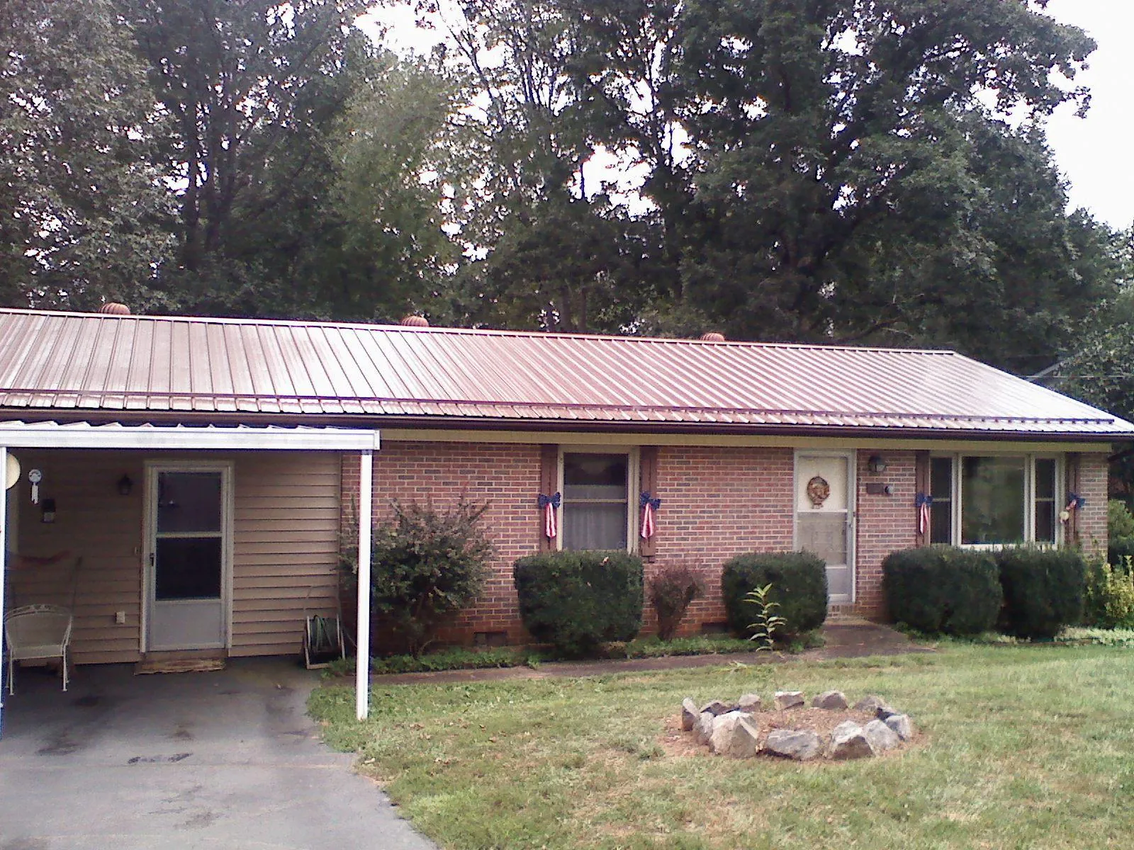 Bronze metal roof and carport on a brick ranch home — Roof Repair work by our crew in Old Orchard Beach